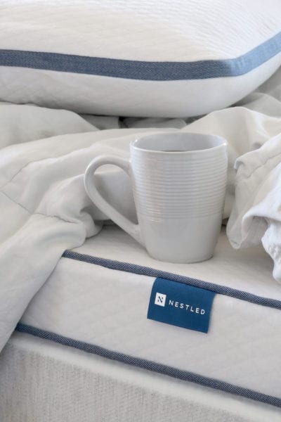 A coffee cup resting gently on a Nestled organic mattress topper.