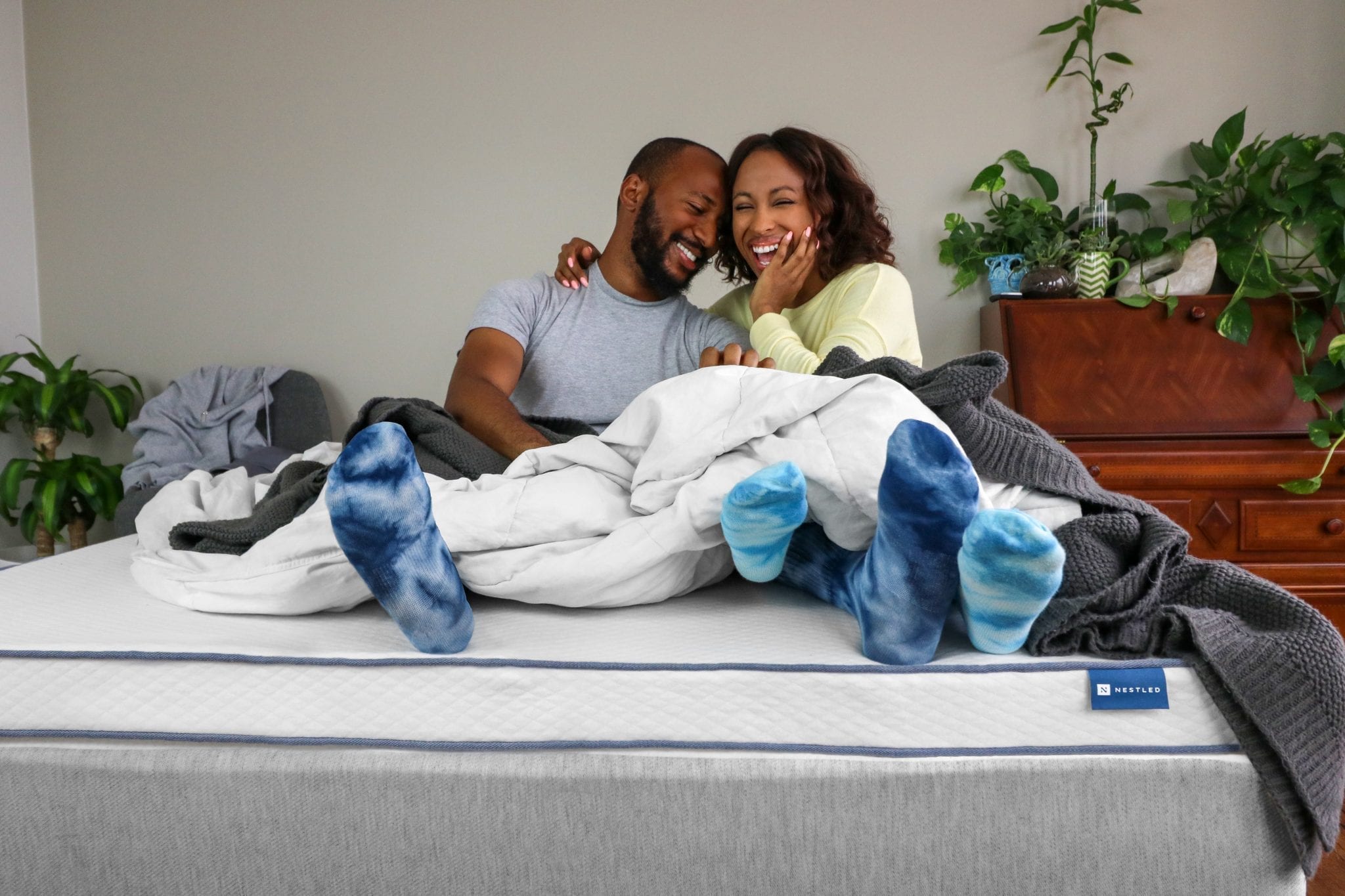 A happy couple enjoying their Nestled latex mattress topper.