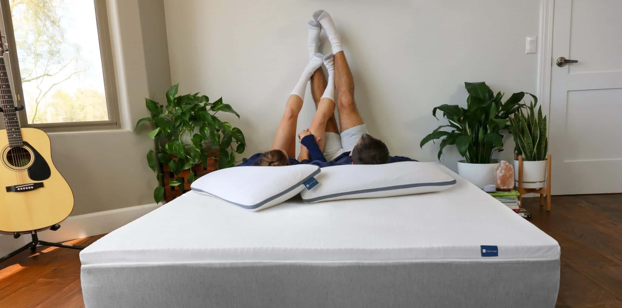 A couple hanging out on top of their Naturally Nestled organic mattress topper.