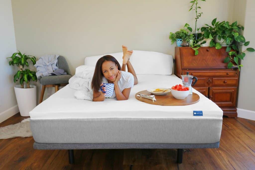 a woman on a bed with a breakfast tray