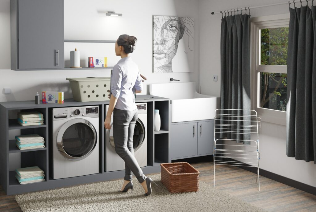 A woman standing in front of a washer and dryer