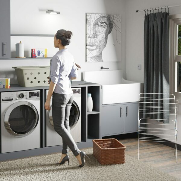 A woman standing in front of a washer and dryer
