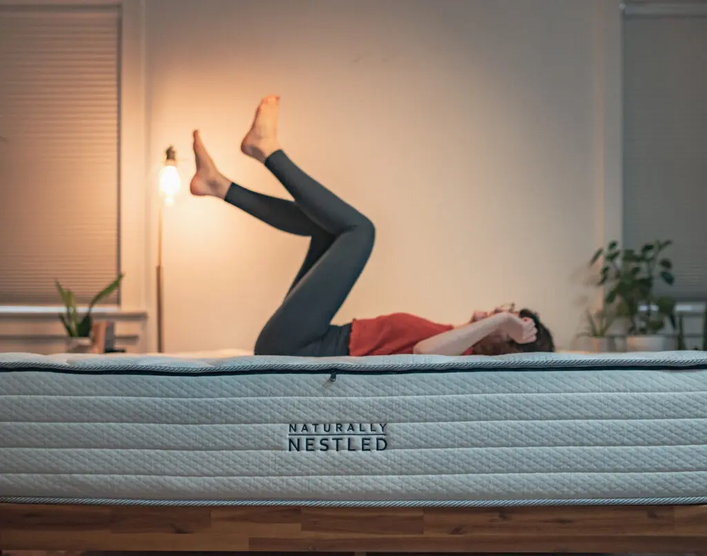A woman relaxes on a mattress with her feet up in the air