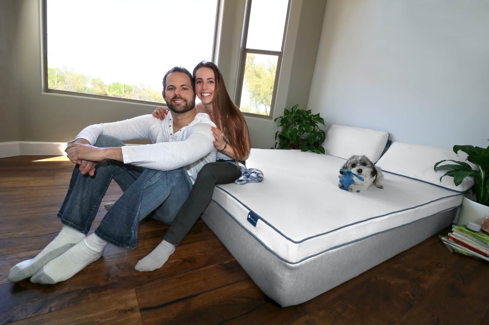 A couple sitting by the most durable mattress from Naturally Nestled