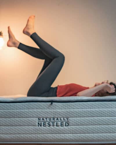 A woman lies on a latex mattress for chronic pain with her feet up in the air