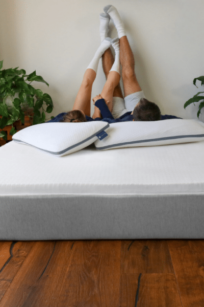 A couple relaxes on a mattress and mattress topper from Naturally Nestled, after researching how often should you change mattress toppers and replacing their old one