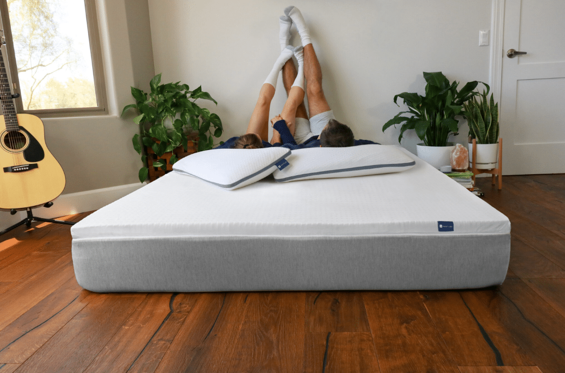 A couple relaxes on a mattress and mattress topper from Naturally Nestled, after researching how often should you change mattress toppers and replacing their old one