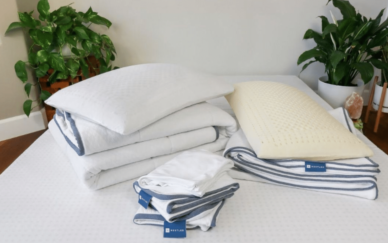 Natural bedding from Naturally Nestled folded on top of a mattress