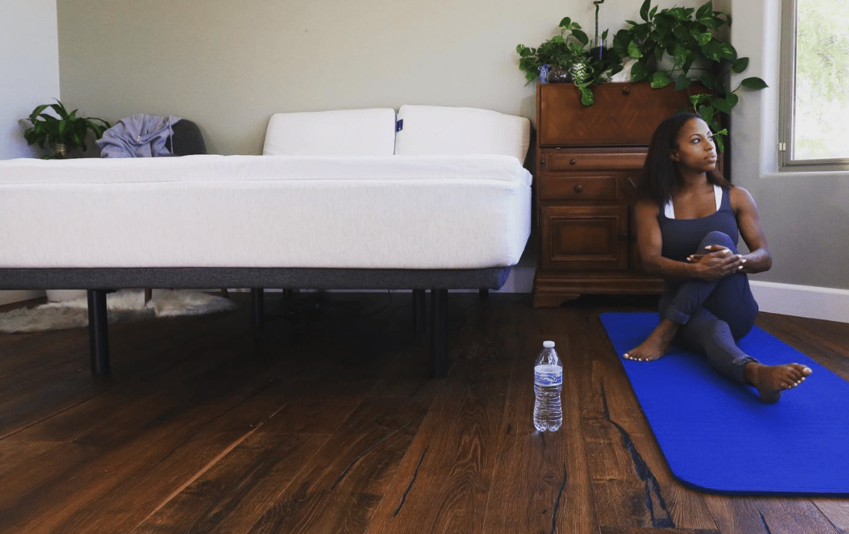 A woman doing yoga next to an eco-friendly mattress topper