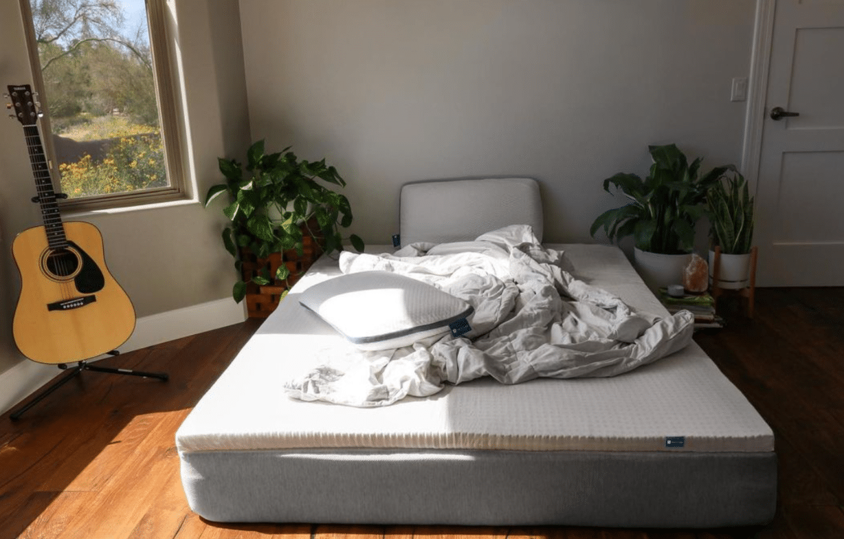 Eco-friendly bedding from Naturally Nestled in a sun-lit bedroom