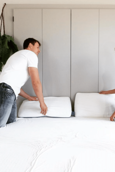 A man and a woman standing by an organic latex mattress