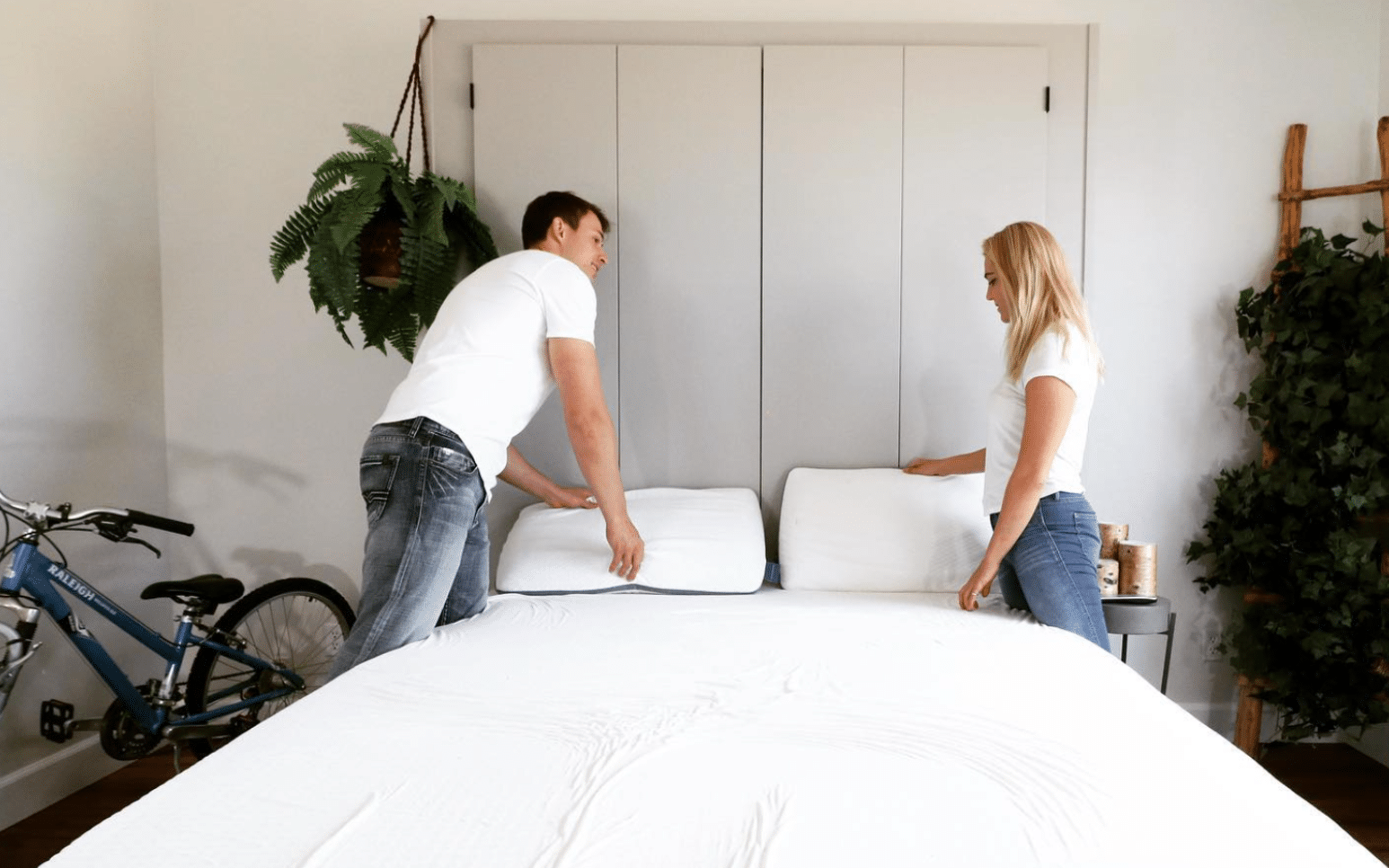 A man and a woman standing by an organic latex mattress
