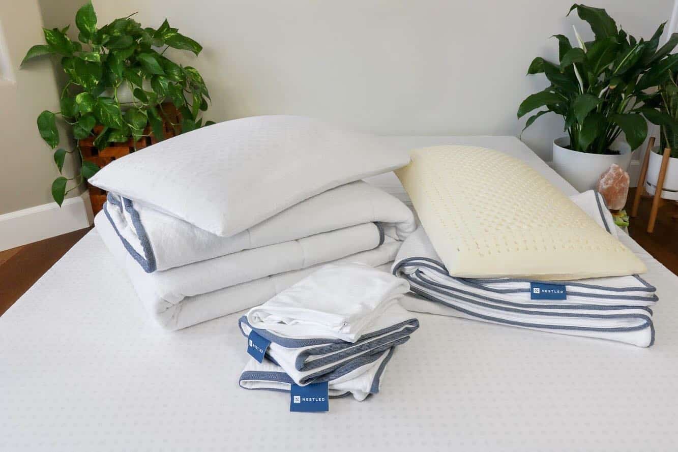 A stack of natural pillows and pillowcases on a mattress