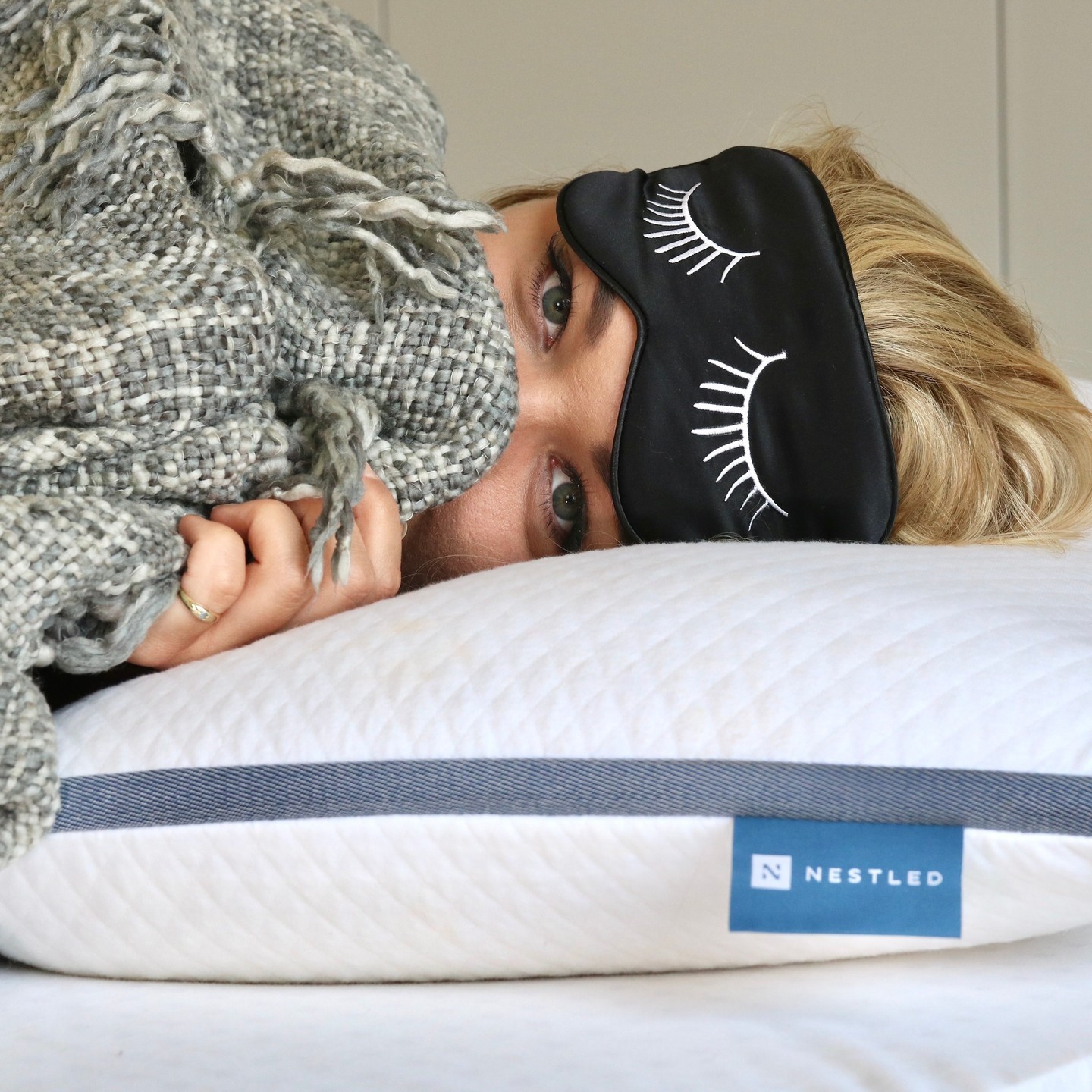 Woman with a sleep mask and a Naturally Nestled pillow