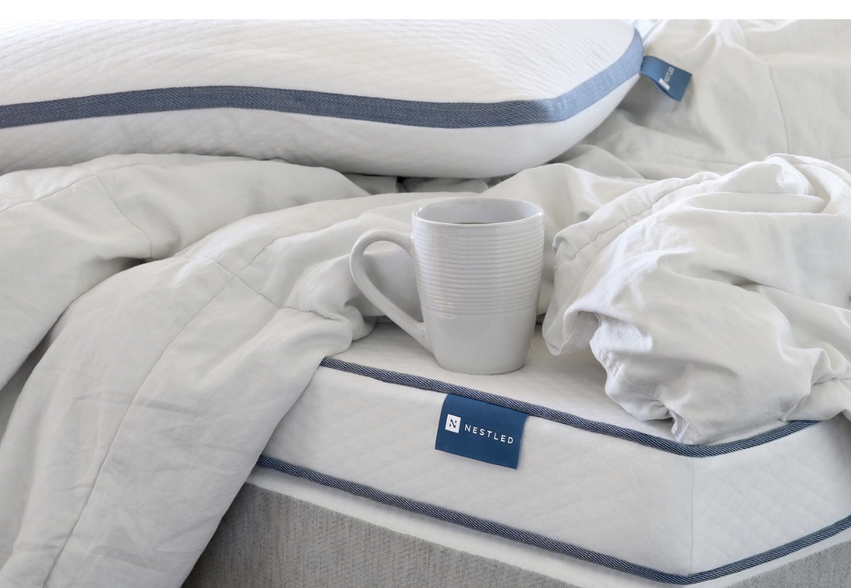 A cup sits on a mattress from Naturally Nestled that excludes fiberglass in mattresses manufacturing