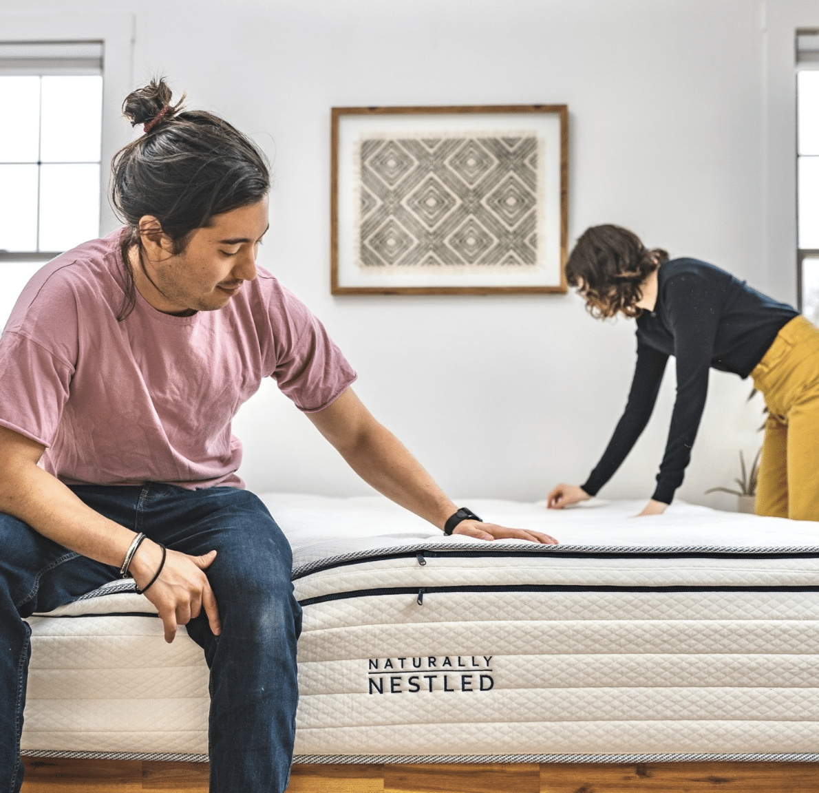 A couple checks their latex mattress in their bedroom