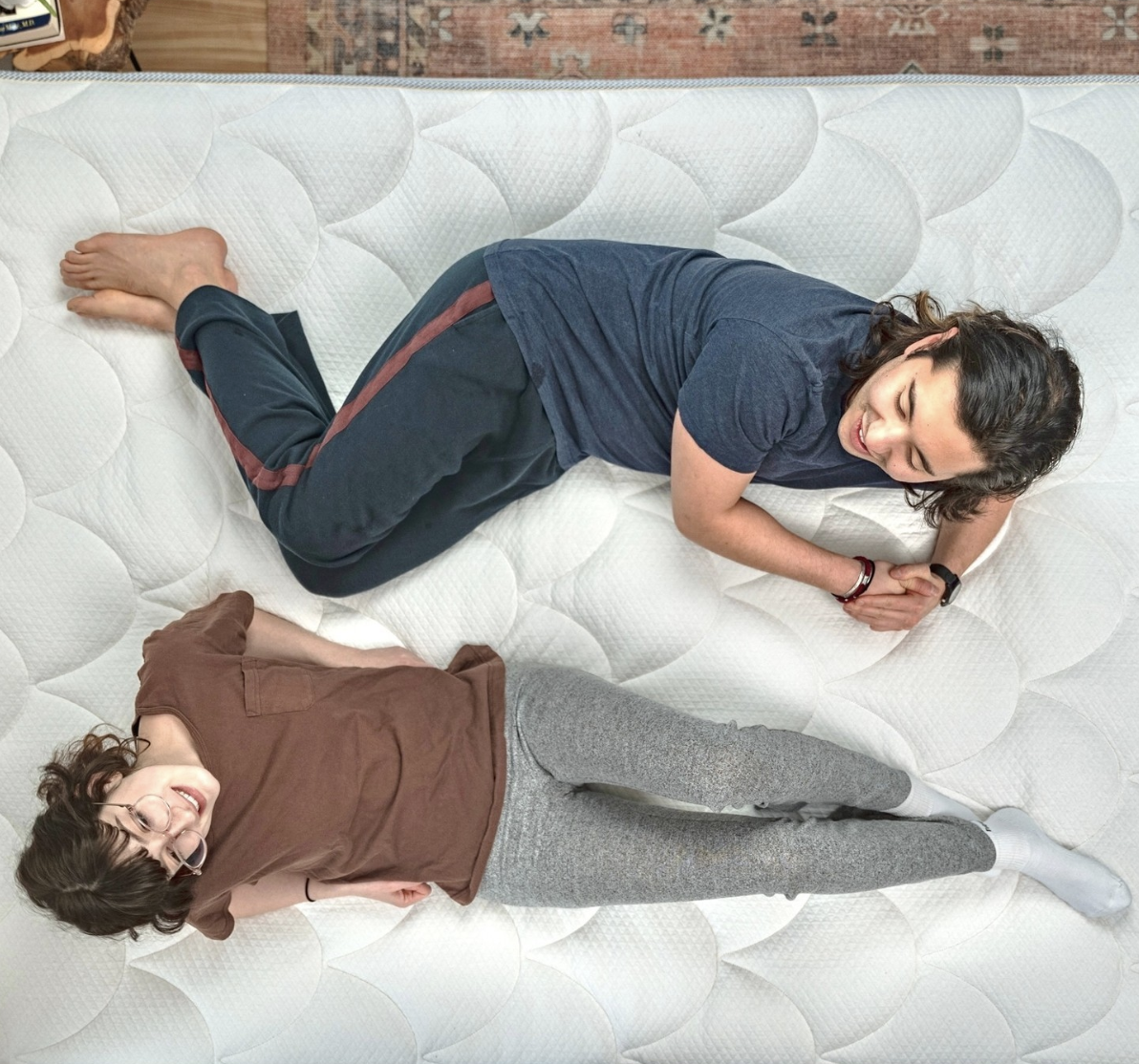 A young couple lays on their latex mattress 