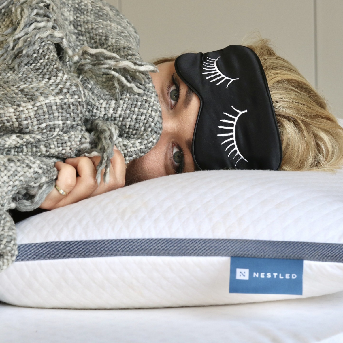 Woman laying on her Naturally Nestled best mattress toppers for dorm beds ready for a good night’s sleep